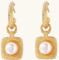 Gold-plated textured hoop earrings with square pendants containing freshwater pearls on white background
