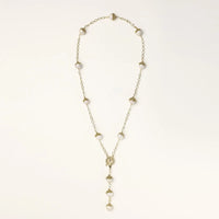 Gold-plated lariat necklace with baroque pearls and textured caps on cream background, showing adjustable Y-shaped design.