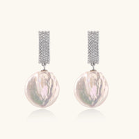 Rhodium-plated silver curved stud with pave stones and baroque pearl drop on white background