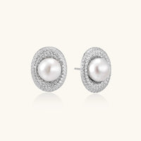 Oval rhodium-plated silver studs featuring freshwater pearls surrounded by pavé crystal halo on white background