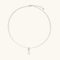Dainty necklace with lavender crystal beads, freshwater pearls, geometric pendant, and large pearl drop on white background.