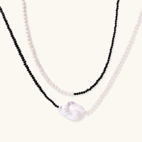 Double-strand necklace with black faceted quartz and white pearls featuring an oversized baroque pearl centerpiece