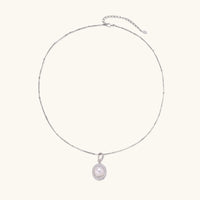 Oval sterling silver pendant with crystal halo surrounding a white freshwater pearl on delicate chain