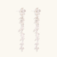 Long sterling silver drop earrings with delicate floral vine design and crystal accents on white background