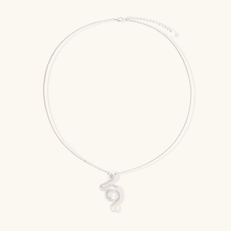 Abstract S-curve sterling silver pendant with zirconia accents on delicate chain against white background