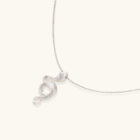 Abstract S-curve sterling silver pendant with zirconia accents on delicate chain against white background