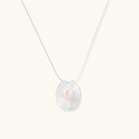 Sterling silver disc necklace with textured finish and centered freshwater pearl on delicate chain