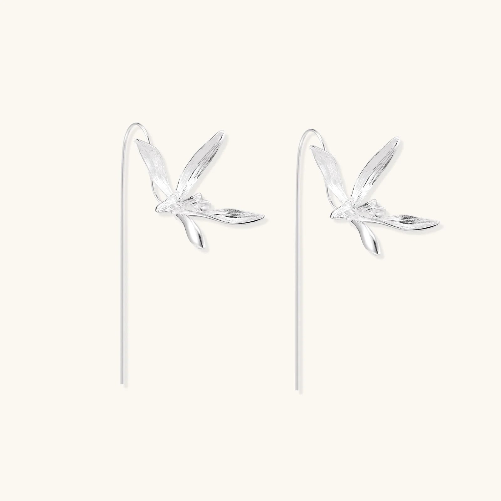 Delicate sterling silver dragonfly earrings with textured wings and curved threader hooks on white background