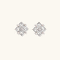 Ornate sterling silver stud earrings with mandala-inspired filigree pattern and four freshwater pearls on beige background
