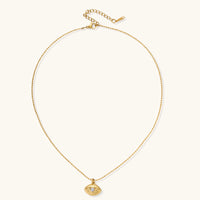 Layered necklace with green stone beads, gold spacers, white accents, and protective eye pendant on cream background.