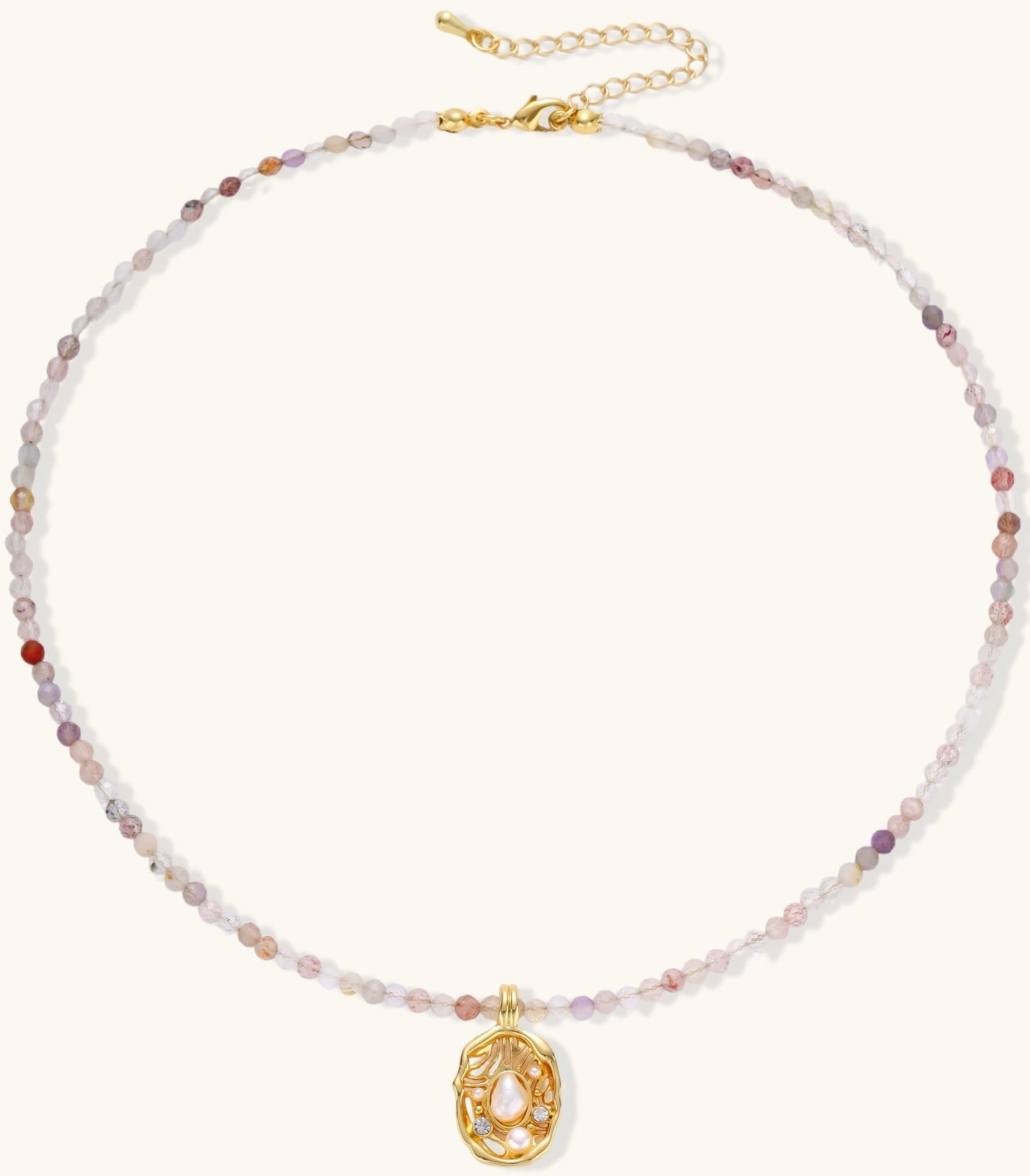 Delicate gold-plated necklace with mixed gemstone beads and ornate oval pendant on white background