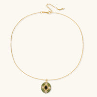 Gold-plated pendant necklace with green enamel background and oval olive cubic zirconia center stone with crystal accents.