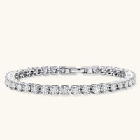 Sterling silver tennis bracelet with continuous row of brilliant moissanite stones and secure clasp closure on cream background.