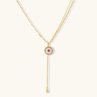 Gold-plated circular medallion necklace set with white enamel base and pink cubic zirconia accent stones