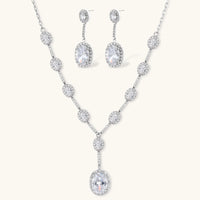 Elegant white gold plated jewelry set with oval cubic zirconia stones in halo settings, featuring Y-necklace and drop earrings.
