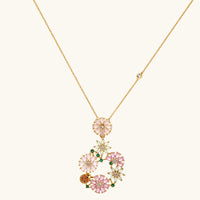 14K gold plated jewelry set with pink and green cubic zirconia flowers arranged in wreath design on cream background