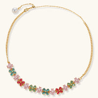 Gold-plated jewelry set with pink, turquoise and red flower-shaped cubic zirconia stones, featuring necklace, earrings and bracelet.