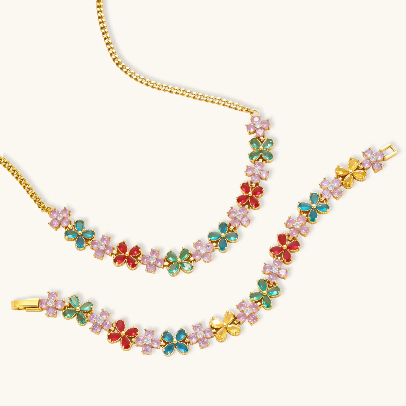 Gold-plated jewelry set with pink, turquoise and red flower-shaped cubic zirconia stones, featuring necklace, earrings and bracelet.