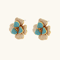 14K gold-plated floral jewelry set with blue cubic zirconia centers and pearl chain details on white background.