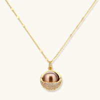 Elegant spherical pendant necklace and earrings set featuring crystal-pavé bottom half in gold or silver finish on white background.