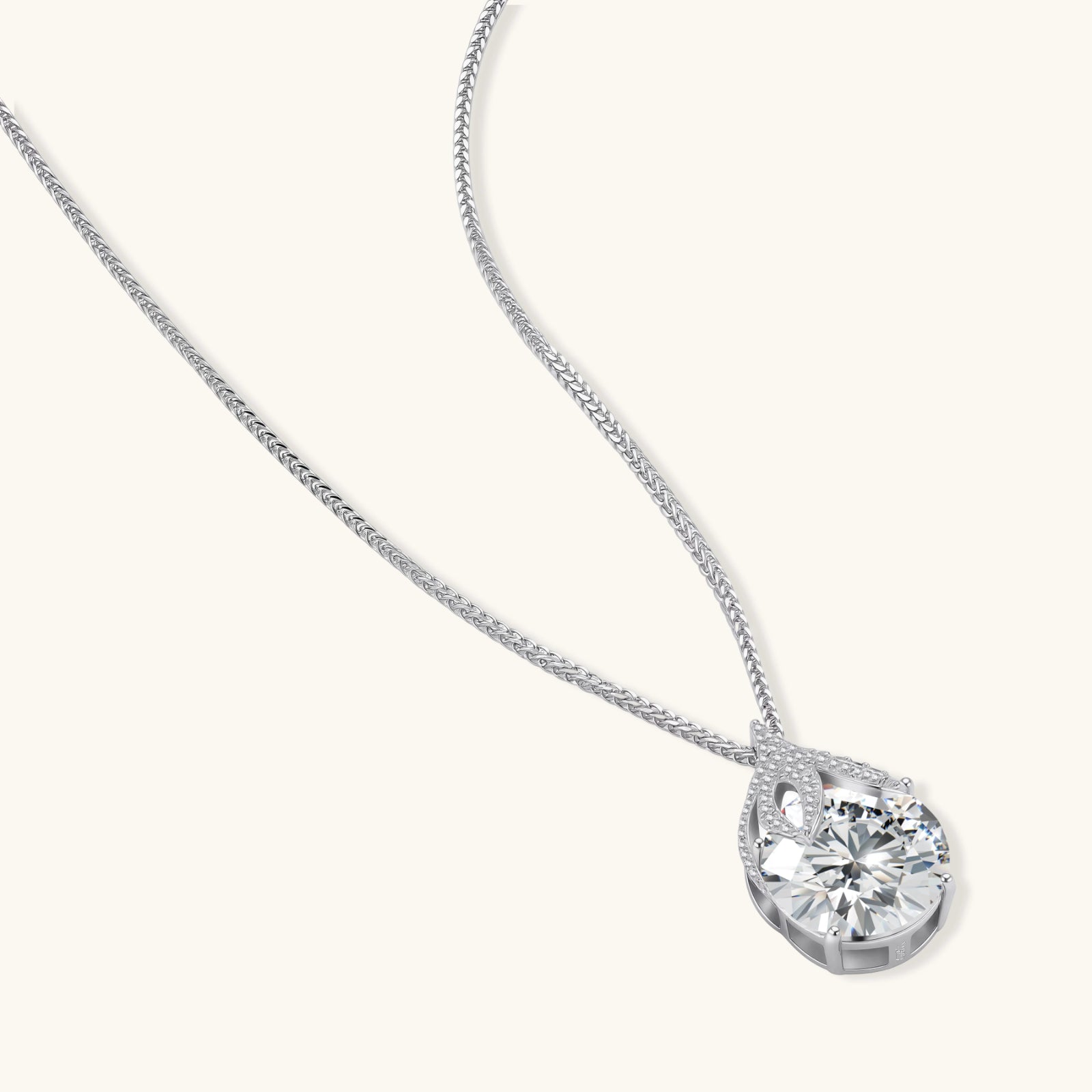 Sterling silver necklace featuring a large pear-shaped moissanite stone in an ornate setting with smaller accent stones