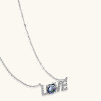 Sterling silver LOVE necklace with brilliant moissanite center stone and pavé details on neutral background.