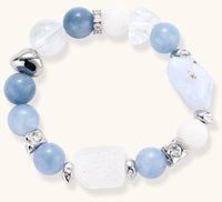 Stretchable bracelet with blue aquamarine beads, clear quartz crystals and copper accents on white background.