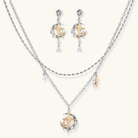 Delicate eco-brass jewelry set featuring gold star and silver moon crescents with clear zirconia crystal drops on cream background