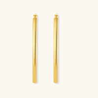 Set of geometric gold-plated sterling silver hoop earrings in oval and cushion shapes on cream background