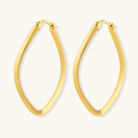 Set of geometric gold-plated sterling silver hoop earrings in oval and cushion shapes on cream background