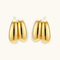 Chunky 18K gold-plated sterling silver hoop earrings with flowing sculptural curves on white background.
