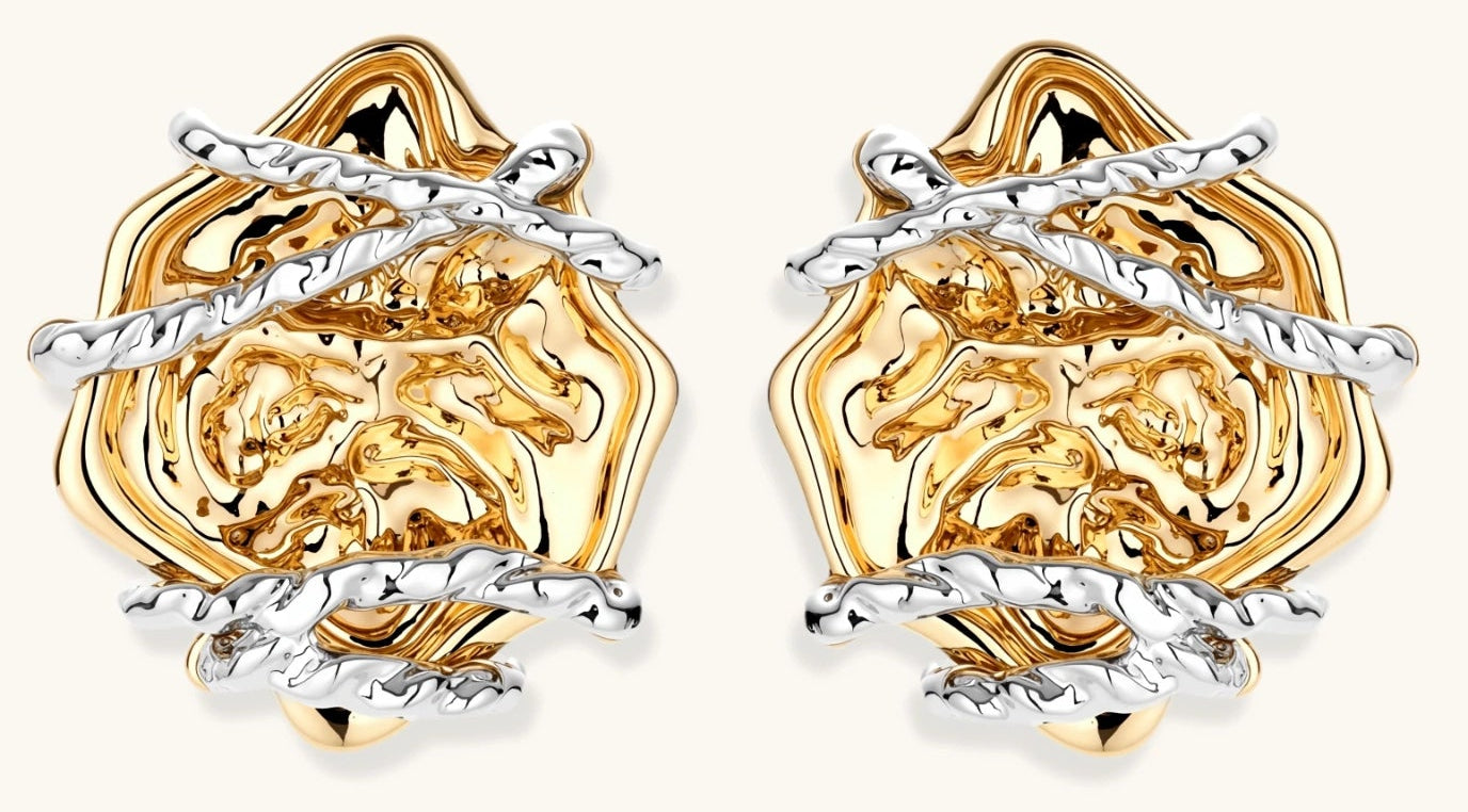 Sculptural rose-shaped stud earrings in gold with silver wire details and S925 posts on cream background.