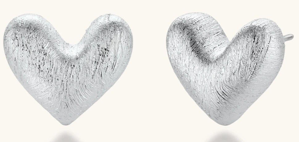 Pair of brushed platinum-plated 925 sterling silver puffy heart stud earrings on a cream background.