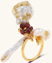 Adjustable gold-plated ring featuring clustered baroque pearls with golden inclusions and burgundy gemstones in sculptural arrangement.