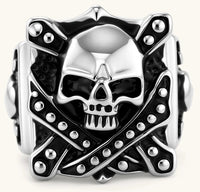 Silver-tone 316L stainless steel skull ring with crossbones, black enamel fill, studded details, and wide shank, 21mm top width.