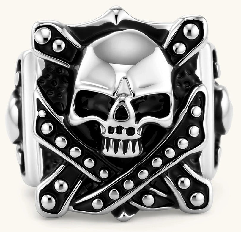 Silver-tone 316L stainless steel skull ring with crossbones, black enamel fill, studded details, and wide shank, 21mm top width.