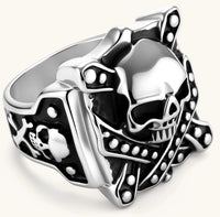Silver-tone 316L stainless steel skull ring with crossbones, black enamel fill, studded details, and wide shank, 21mm top width.