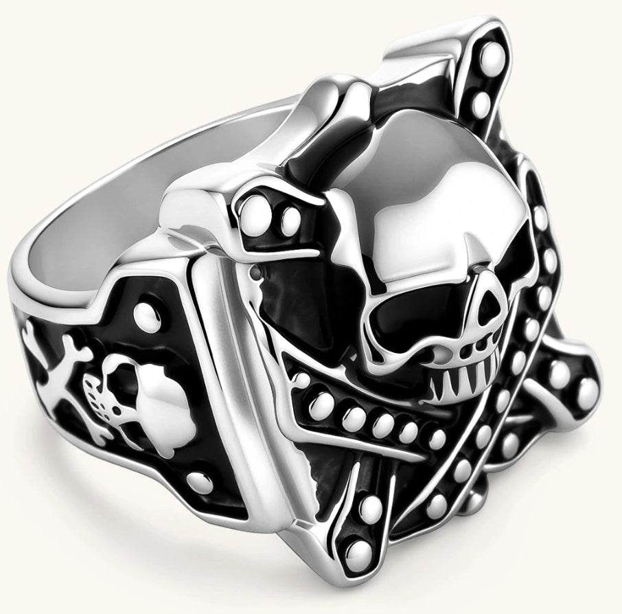 Silver-tone 316L stainless steel skull ring with crossbones, black enamel fill, studded details, and wide shank, 21mm top width.