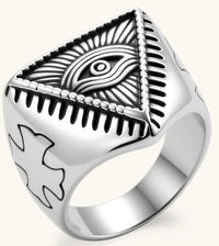Silver stainless steel signet ring with engraved all-seeing eye in triangle, radiating lines, and cross motifs on the band.