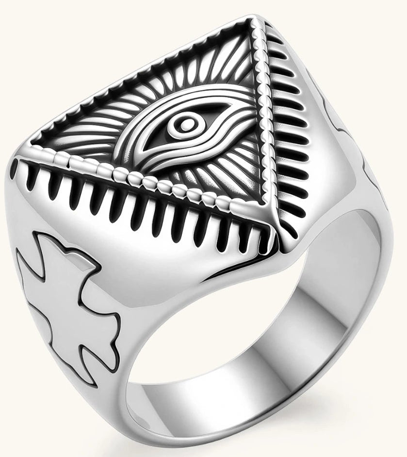 Silver stainless steel signet ring with engraved all-seeing eye in triangle, radiating lines, and cross motifs on the band.