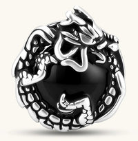Silver stainless steel stud earring with coiled dragon motif wrapped around a black stone, shown from front and side.