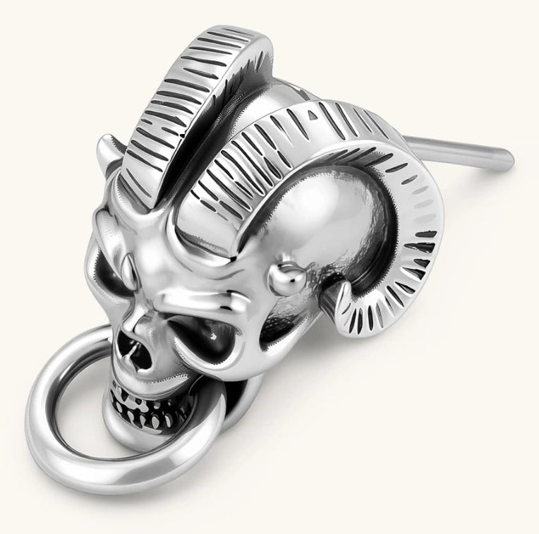 Silver 316L stainless steel stud earring shaped as a horned demon skull with ram horns and a dangling mouth ring.