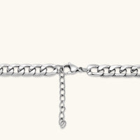 Silver 316L stainless steel carved curb chain necklace with lobster clasp and extender, 7.2mm wide, on cream background.