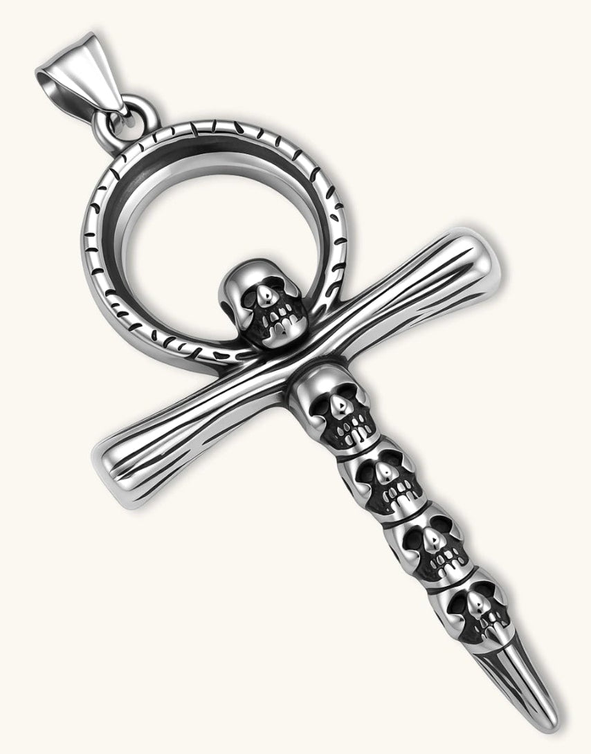 Silver stainless steel ankh pendant with skull motifs on vertical bar and textured ring top, on a box chain necklace.