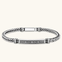 Silver stainless steel men's bracelet with braided foxtail chain, Greek key engraved bar, and decorative cube connectors.