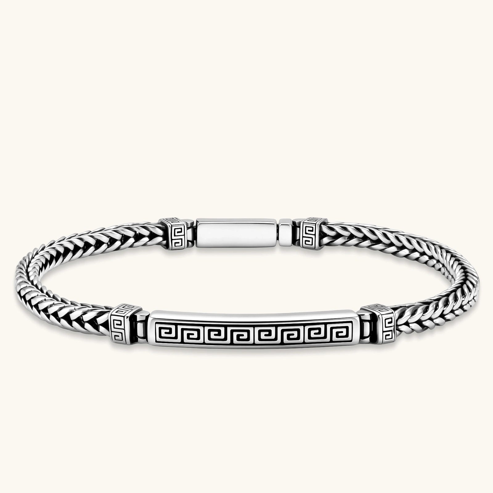 Silver stainless steel men's bracelet with braided foxtail chain, Greek key engraved bar, and decorative cube connectors.