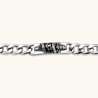 Silver 316L stainless steel Cuban chain bracelet with blackened skull and crown ID bar centerpiece, lobster clasp closure.