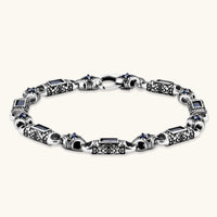 Oxidized silver stainless steel link bracelet with baguette blue CZ stones and intricate scroll engravings, lobster clasp.