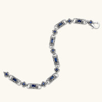 Oxidized silver stainless steel link bracelet with baguette blue CZ stones and intricate scroll engravings, lobster clasp.