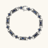 Oxidized silver stainless steel link bracelet with baguette blue CZ stones and intricate scroll engravings, lobster clasp.